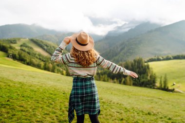 Bir dağ vadisinde seyahat eden genç ve çekici bir kız yolcunun portresi. Macera, seyahat konsepti.