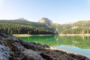 Gölün dağlarında inanılmaz bir manzara. Sabah Dağ Gölü 'nün kayalık kıyısı. Seyahat için ünlü bir yer.
