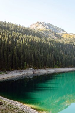 Gölün dağlarında inanılmaz bir manzara. Sabah Dağ Gölü 'nün kayalık kıyısı. Seyahat için ünlü bir yer.