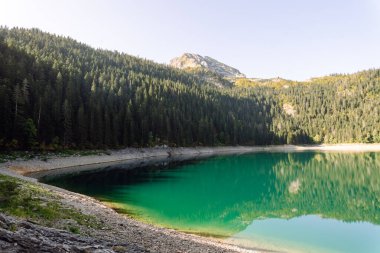 Gölün dağlarında inanılmaz bir manzara. Sabah Dağ Gölü 'nün kayalık kıyısı. Seyahat için ünlü bir yer.