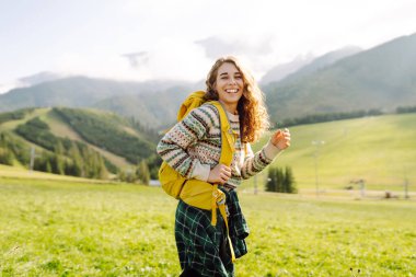 Yürüyüşçü vadideki yeşil bir vadide dağ manzarası seyrediyor. Seyahat, doğa konsepti..
