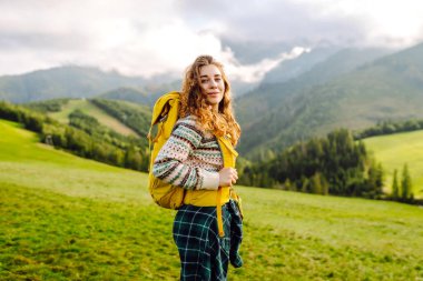 Yürüyüşçü vadideki yeşil bir vadide dağ manzarası seyrediyor. Seyahat, doğa konsepti..