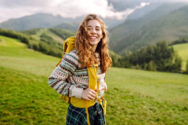 Yürüyüşçü vadideki yeşil bir vadide dağ manzarası seyrediyor. Seyahat, doğa konsepti..