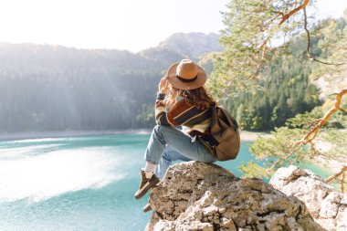 Tatil yapan, orman ve dağların yakınında poz veren sıradan bir kadın resmi. Aktif hayat. Yaşam tarzı, seyahat, turizm