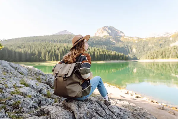 Tatil yapan, orman ve dağların yakınında poz veren sıradan bir kadın resmi. Aktif hayat. Yaşam tarzı, seyahat, turizm