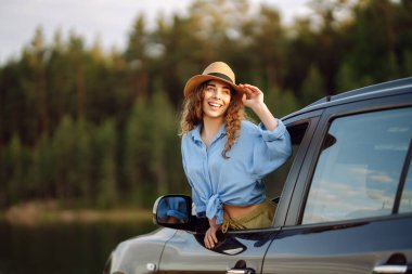 Arabasının camından dışarı sarkan bir kadın, özgürlük araba yolculuğu konsepti. Yolculuk.