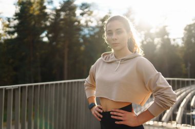 Gülen kadın sabah koşuya çıkmadan önce bacaklarını esnetiyor. Spor, spor ve sağlıklı vücut konsepti..