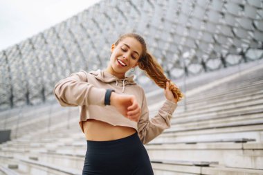 Gülen kadın sabah koşuya çıkmadan önce bacaklarını esnetiyor. Spor, spor ve sağlıklı vücut konsepti..