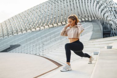 Gülen kadın sabah koşuya çıkmadan önce bacaklarını esnetiyor. Spor, spor ve sağlıklı vücut konsepti..