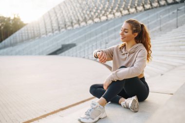Gülen kadın sabah koşuya çıkmadan önce bacaklarını esnetiyor. Spor, spor ve sağlıklı vücut konsepti..
