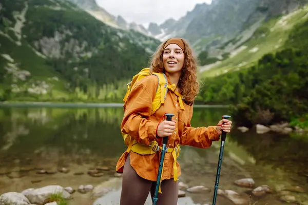 Woman Traveler Yellow Hiking Backpack Hiking Stiks Enjoys Scenery Active Rechtenvrije Stockafbeeldingen