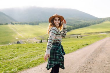 Güzel genç bir kadın dağın yamaçlarında eğleniyor. Seyahat, doğa konsepti.. 