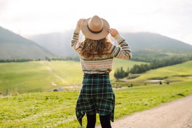 Güzel genç bir kadın dağın yamaçlarında eğleniyor. Seyahat, doğa konsepti.. 