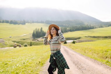 Güzel genç bir kadın dağın yamaçlarında eğleniyor. Seyahat, doğa konsepti.. 