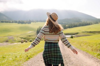 Güzel genç bir kadın dağın yamaçlarında eğleniyor. Seyahat, doğa konsepti.. 