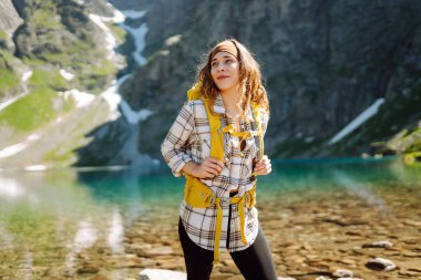 Aktif kadın görkemli dağların ve gölün güzel manzarasının tadını çıkarıyor. Seyahat, macera. Etkin yaşam.