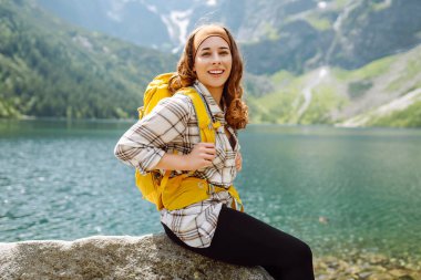 Gezgin kadın, dağ gölüne bak. Çekici kız açık hava yaşam tarzını seviyor. Doğası güzel görünüyor. Seyahat ve aktif yaşam konsepti. Macera ve dağlarda seyahat.