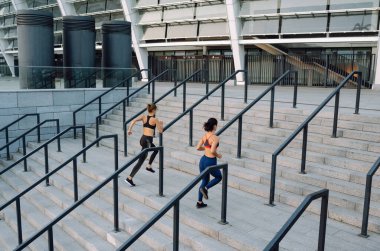 Dışarıda egzersiz yapan iki çekici kadın. Esneme, zindelik, spor ve sağlıklı yaşam tarzı kavramı