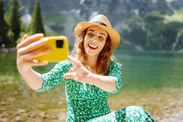 Seyahat ederken selfie. Mutlu kadın yürüyor ve akıllı telefon kamerasıyla selfie çekiyor. Spor, teknoloji ve seyahat yaşam tarzı