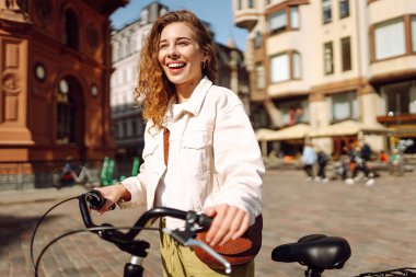 Şehir caddesinde bisiklet süren güzel bir kadın. Aktif yaşam tarzı. Eko taşımacılığı.