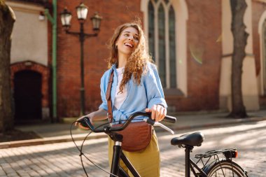 Şehir caddesinde bisiklet süren güzel bir kadın. Aktif yaşam tarzı. Eko taşımacılığı.