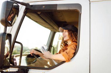 Büyük bir kamyonda oturan genç ve güzel bir kadının portresi. İnsanlar ve ulaşım.