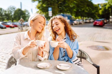 Arkadaşlık kavramı. İki kız arkadaş, dedikodu yaparken ve boş zaman geçirirken birlikte kahvaltı yapıyorlar..