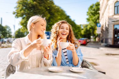 Arkadaşlık kavramı. İki kız arkadaş, dedikodu yaparken ve boş zaman geçirirken birlikte kahvaltı yapıyorlar..