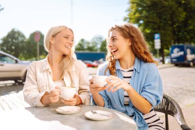 Arkadaşlık kavramı. İki kız arkadaş, dedikodu yaparken ve boş zaman geçirirken birlikte kahvaltı yapıyorlar..