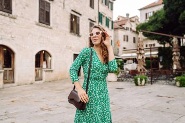 Sokakta poz veren modaya uygun yaz elbiseli güzel bir kadın. Moda tarzı. Turistik cazibe. Tatil ve seyahat kavramı.