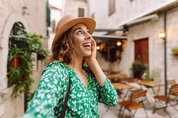 Güzel bir kadın sokakta yürüyor ve akıllı telefon kamerasıyla selfie çekiyor. Blogculuk, teknoloji, yaşam tarzı, seyahat, turizm, aktif yaşam.