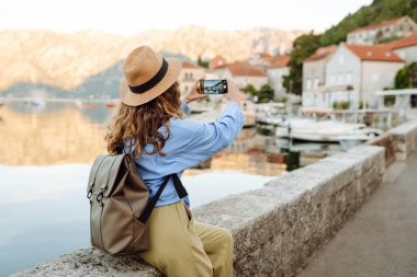 Kadın turist, blog 'da yayın yapmak için boş zamanlarında kentin resimlerini çekiyor. Yaşam tarzı, seyahat, turizm, teknoloji, blog yazma, iletişim kavramı.