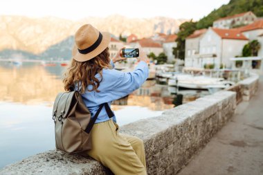 Kadın turist, blog 'da yayın yapmak için boş zamanlarında kentin resimlerini çekiyor. Yaşam tarzı, seyahat, turizm, teknoloji, blog yazma, iletişim kavramı.