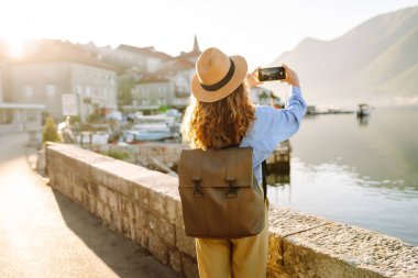 Kadın turist, blog 'da yayın yapmak için boş zamanlarında kentin resimlerini çekiyor. Yaşam tarzı, seyahat, turizm, teknoloji, blog yazma, iletişim kavramı.