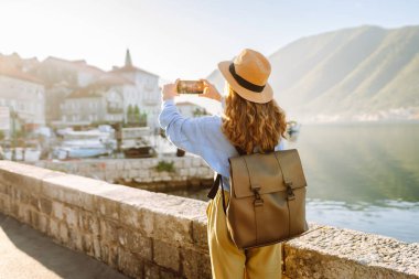 Kadın turist, blog 'da yayın yapmak için boş zamanlarında kentin resimlerini çekiyor. Yaşam tarzı, seyahat, turizm, teknoloji, blog yazma, iletişim kavramı.