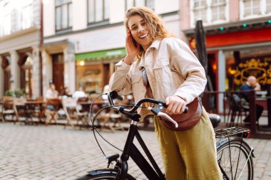 Şehir caddesinde bisiklet kullanan mutlu kadın turist. İşten sonra boş zaman, ders çalışma, yaşam tarzı. Eko taşımacılığı.