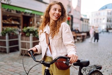 Şehir caddesinde bisiklet kullanan mutlu kadın turist. İşten sonra boş zaman, ders çalışma, yaşam tarzı. Eko taşımacılığı.