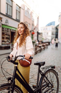 Şehir caddesinde bisiklet kullanan mutlu kadın turist. İşten sonra boş zaman, ders çalışma, yaşam tarzı. Eko taşımacılığı.