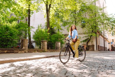 Şehir caddesinde bisiklet kullanan mutlu kadın turist. İşten sonra boş zaman, ders çalışma, yaşam tarzı. Eko taşımacılığı.
