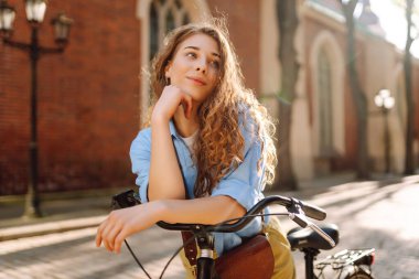 Şehir caddesinde bisiklet kullanan mutlu kadın turist. İşten sonra boş zaman, ders çalışma, yaşam tarzı. Eko taşımacılığı.