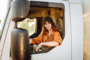 Kamyon süren genç bir kadın. Kamyoncu kadın işçi, ulaşım endüstrisi işgali..