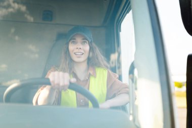 Kamyon süren genç bir kadın. Kamyoncu kadın işçi, ulaşım endüstrisi işgali..