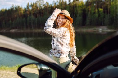 Arabayla seyahat ederken doğanın tadını çıkaran genç bir kadın. Yaşam tarzı, seyahat, turizm, doğa, aktif yaşam.