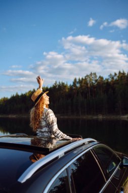Arabayla seyahat ederken doğanın tadını çıkaran genç bir kadın. Yaşam tarzı, seyahat, turizm, doğa, aktif yaşam.