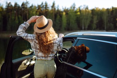 Arabayla seyahat ederken doğanın tadını çıkaran genç bir kadın. Yaşam tarzı, seyahat, turizm, doğa, aktif yaşam.