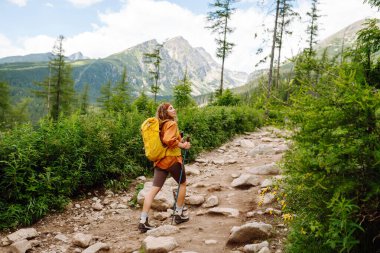 Kayalık dağlarda sırt çantasıyla gezen bir kadın. Seyahat, yaşam tarzı, macera, yaz tatili.