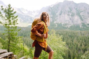 Sırt çantalı aktif kadın turist görkemli dağların güzel manzarasının tadını çıkarıyor. Seyahat, macera. Etkin bir yaşam biçimi kavramı.