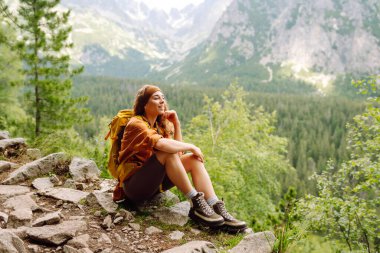 Sırt çantalı aktif kadın turist görkemli dağların güzel manzarasının tadını çıkarıyor. Seyahat, macera. Etkin bir yaşam biçimi kavramı.