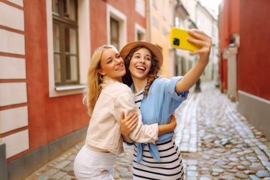 Şehir merkezinde selfie çekerken eğlenen komik, güzel, en iyi arkadaş portresi. Olumlu duygular, Avrupa 'da birlikte seyahat etmek. Moda, seyahat, blog, teknoloji kavramı.
