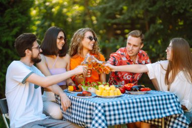 Bir grup arkadaş arka bahçede akşam yemeği partisi veriyor. Gençler dışarıda birlikte vakit geçirip bira ve barbekü içerek eğleniyorlar. Tatil, piknik, hafta sonu, doğa.